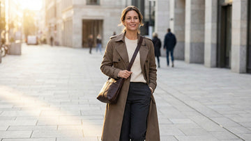 Woman wearing a dark brown genuine leather crossbody bag at hip level on an urban street