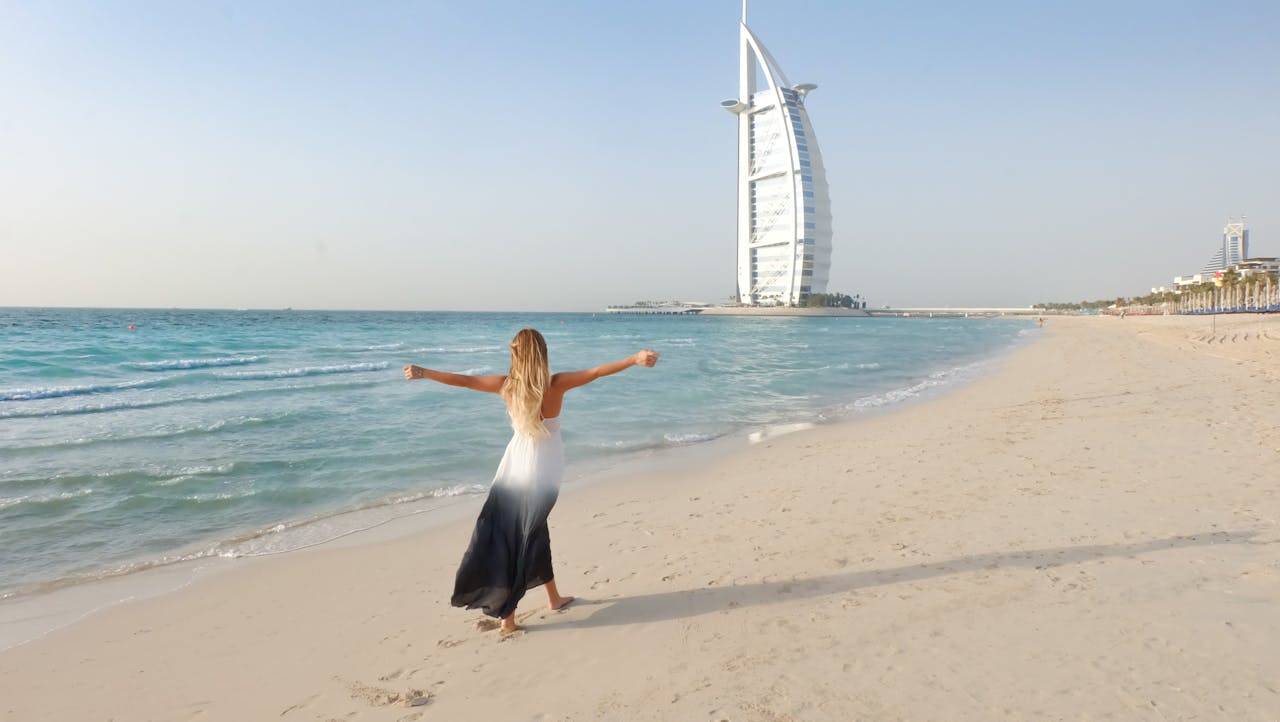 Woman on Dubai Beach with Burj Al Arab in the Background, Enjoying Travel Comfort in Dubai