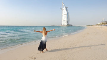 Woman on Dubai Beach with Burj Al Arab in the Background, Enjoying Travel Comfort in Dubai