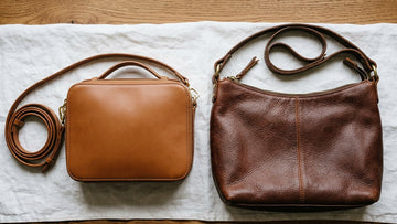 Two genuine leather bags on a wooden surface showing different leather finishes and grades