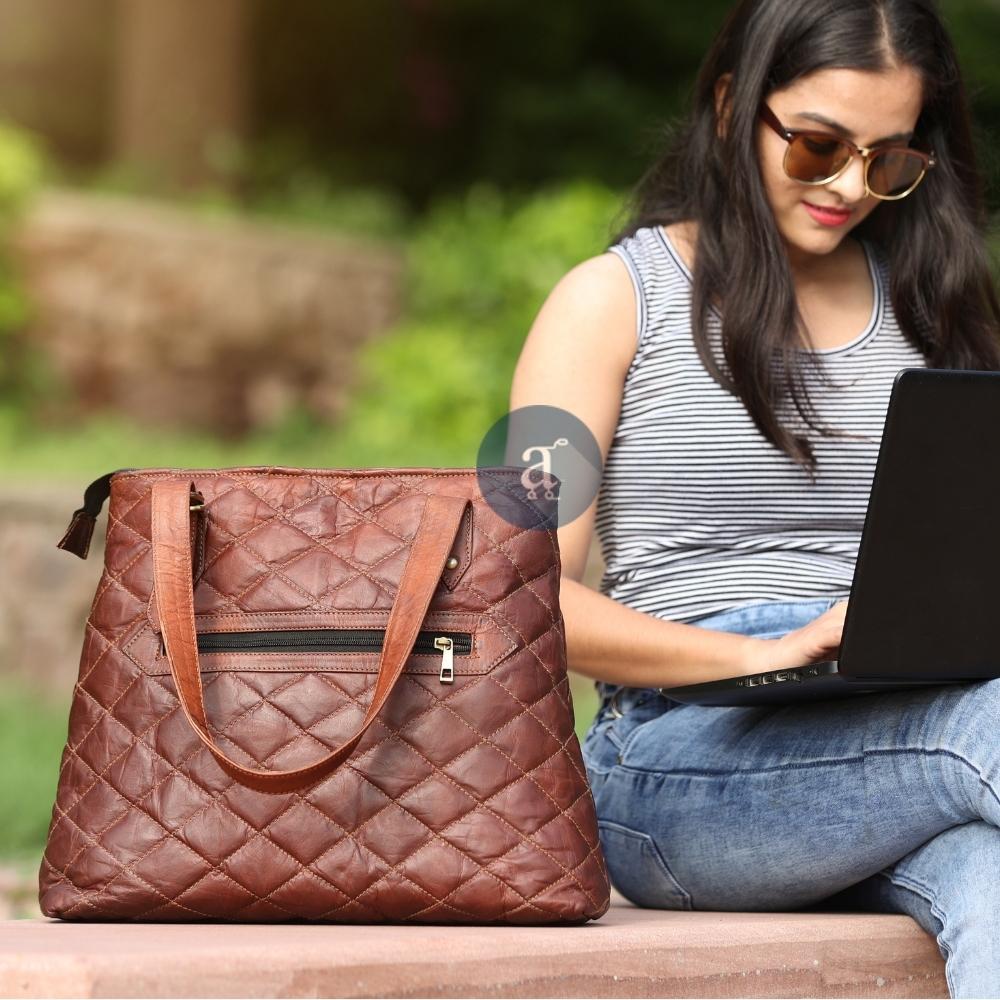 Designer Tote Kept on Left Side of A Women Working on her Laptop