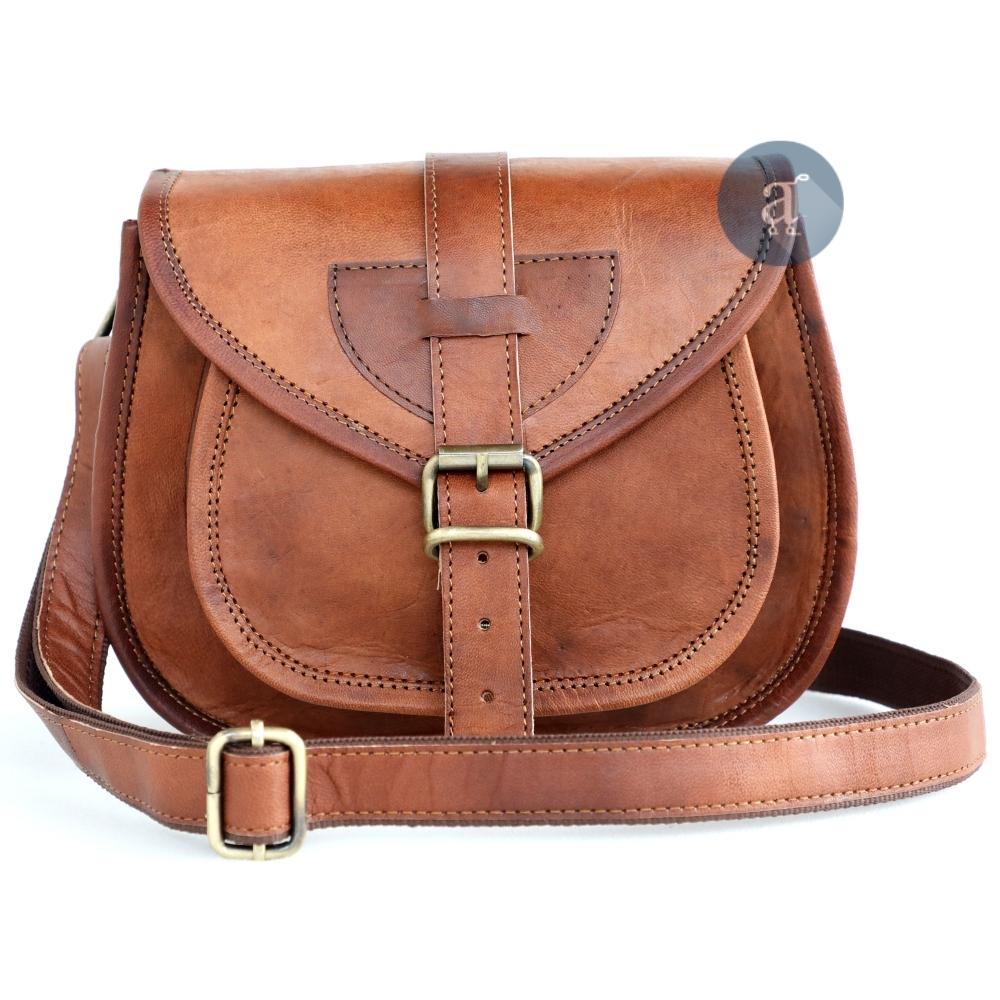 Front View of Brown Leather Saddle Purse with Adjustable Strap and Buckle, Showcasing Fine Stitching and Design