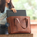 Woman Placing a Laptop into a Brown Leather Laptop Tote Bag