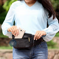 Women Putting Phone in Black Leather Fanny Pack