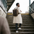 The Convertible leather briefcase worn as a backpack on subway stairs