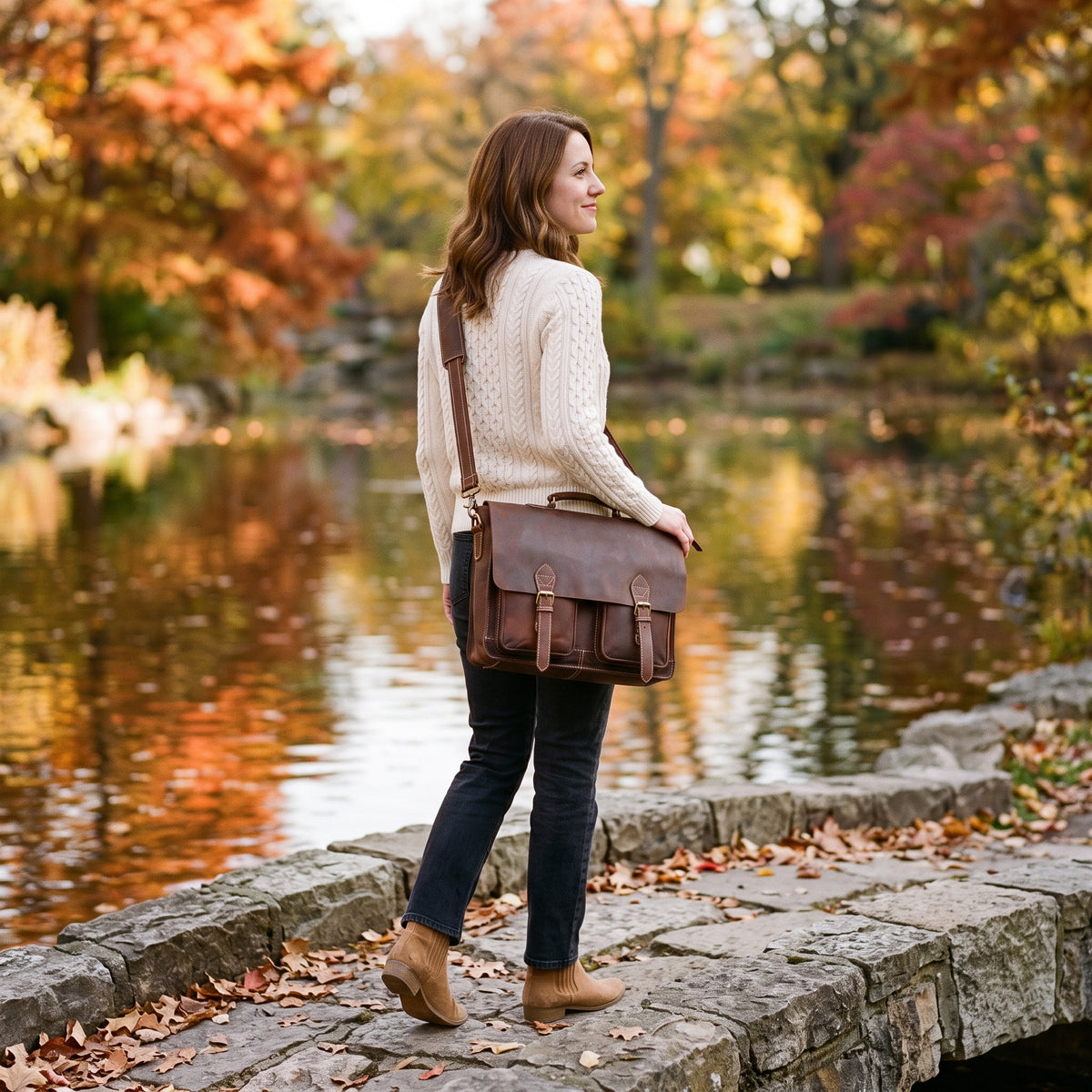 Woman on a lakeside path in autumn wearing The Digital leather laptop messenger bag crossbody