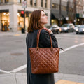 Woman at a city crossing wearing the quilted Leather Tote Bag for Work on her shoulder