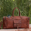 The Yachtsman Duffle Placed On A Stone Bench, With Green Foliage In The Background, Showing Its Elegant Design