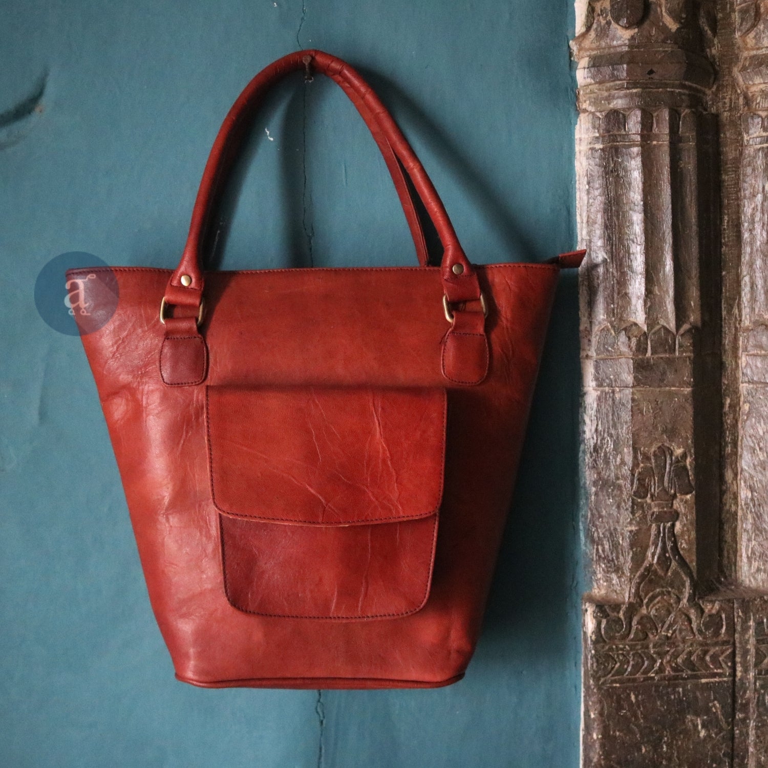 leather tote bag with zipper hanging on the wall
